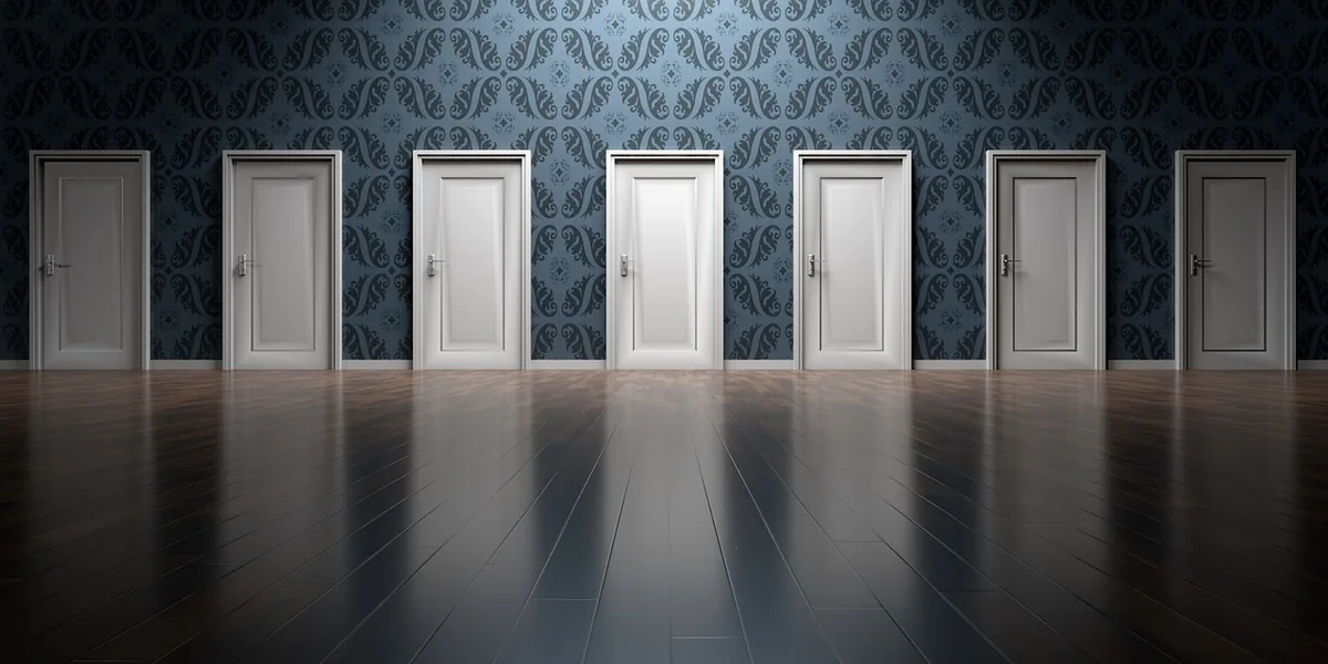 Sept portes blanches identiques alignées le long d’un mur sombre, comme les plaquettes d’écoles de massage impossibles à départager