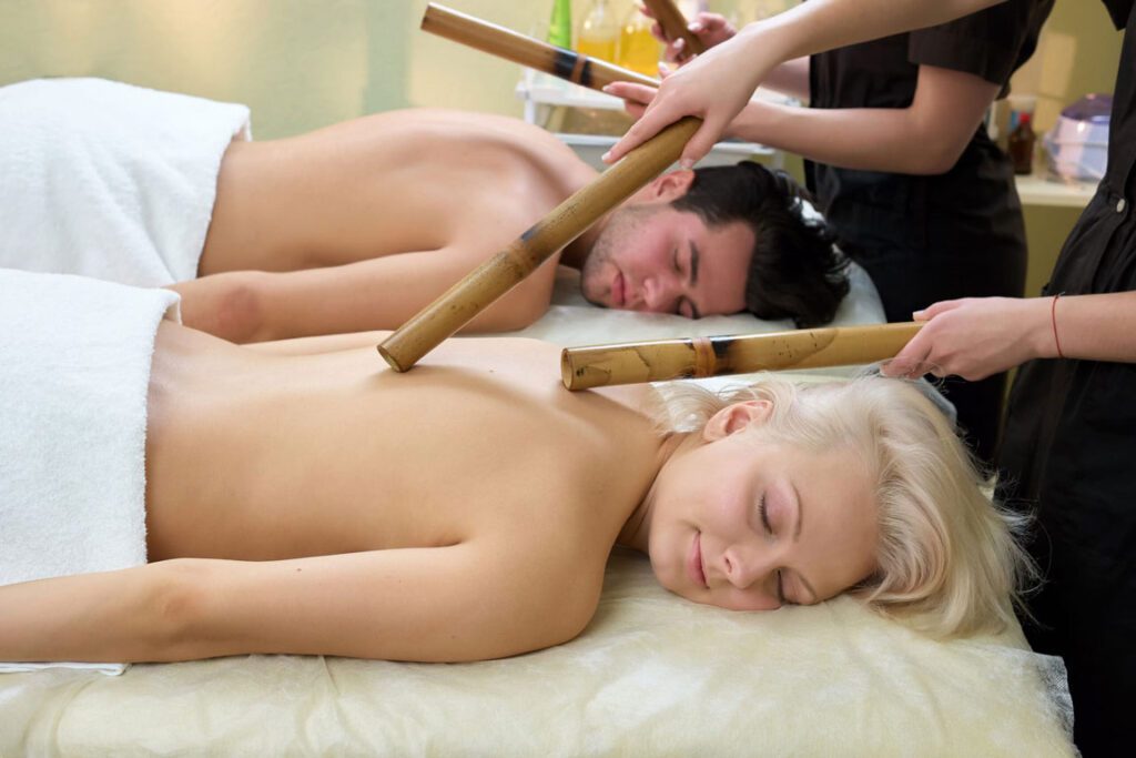 Massage créole avec des bâtons de bambou sur une cliente.