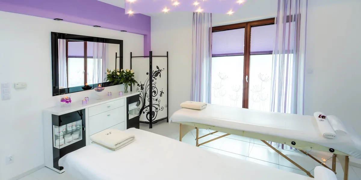 Une cabine de spa équipée de deux tables de massage, le débouché visé à la sortie d’une école de massage